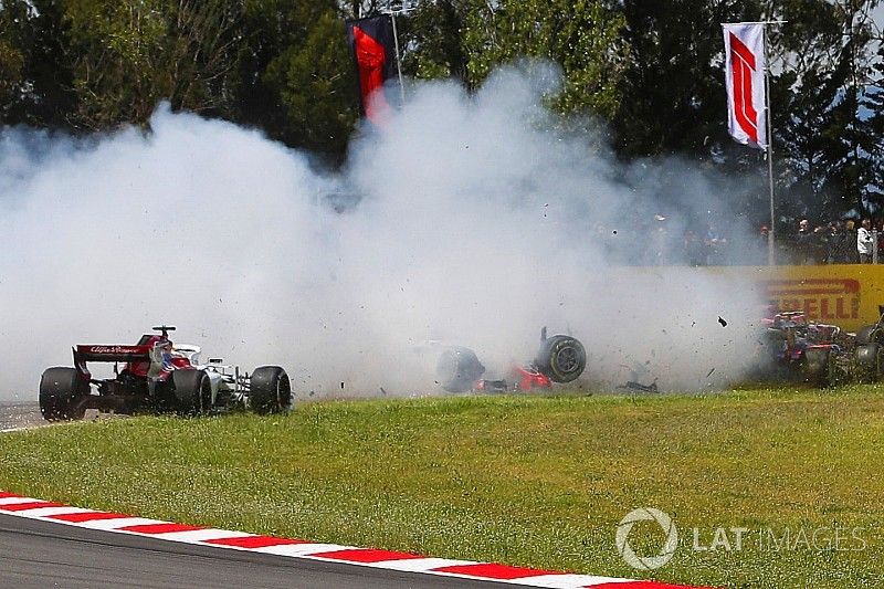 Pierre Gasly, Toro Rosso STR13, and Nico Hulkenberg, Renault Sport F1 Team R.S. 18, collect the spinning Romain Grosjean, Haas F1 Team VF-18