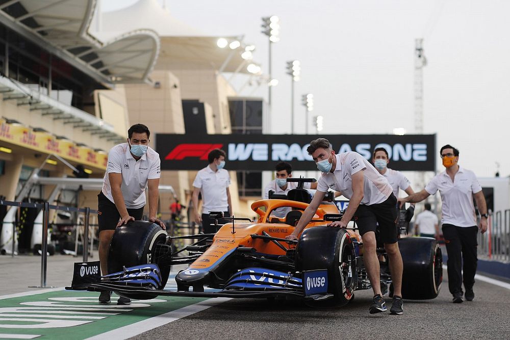 Los mecánicos empujan el McLaren MCL35M de Daniel Ricciardo en el pit lane