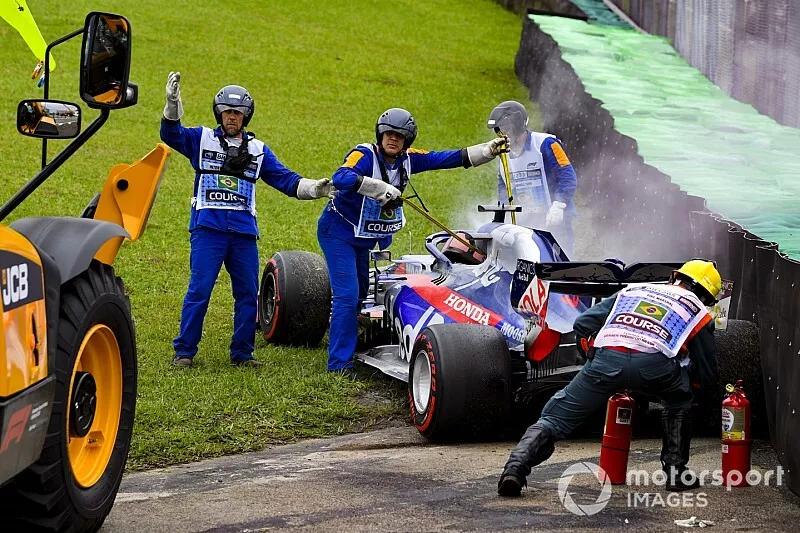 Marshals assist the smoking car of Daniil Kvyat, Toro Rosso STR14, with fire extinguishers