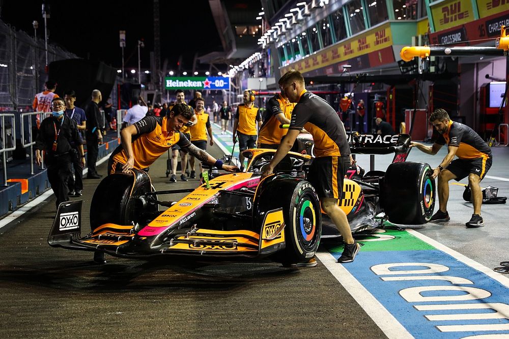 Los mecánicos de McLaren empujan el McLaren MCL36 de Lando Norris en el pit lane