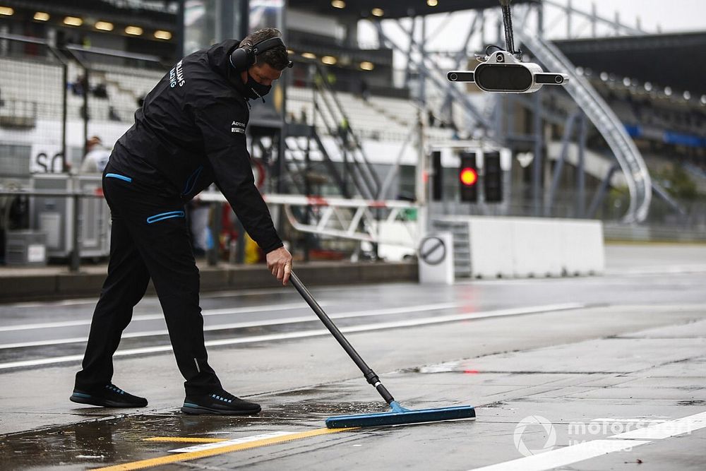 Un miembro de Williams seca el pitlane