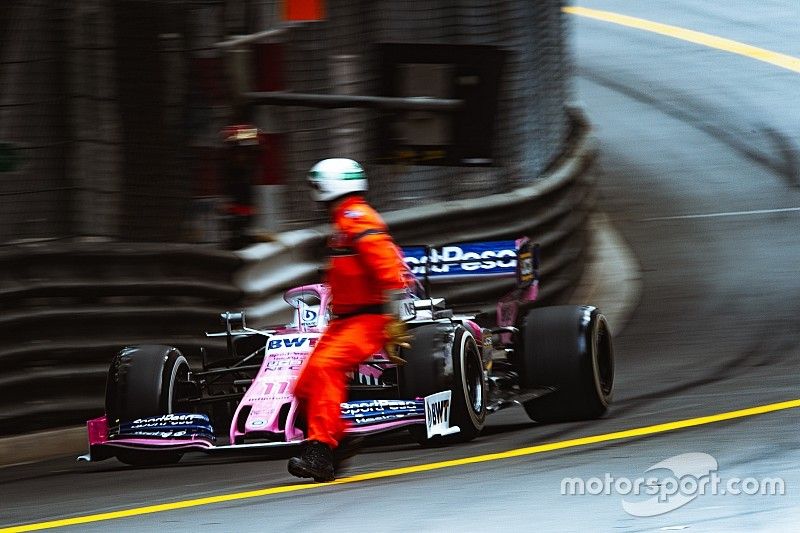 Oficial se cruza la pista por el frente del coche de Sergio Pérez