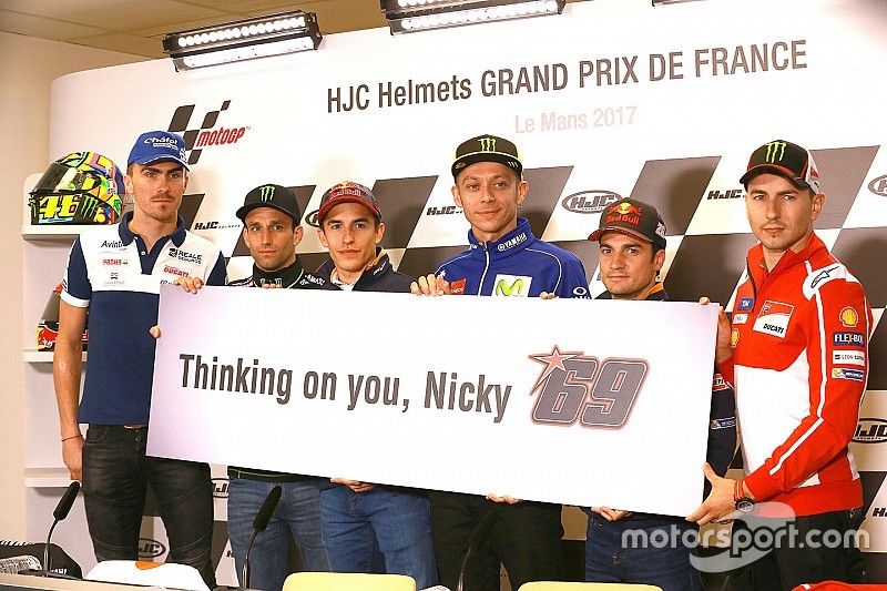 Pilotos con una pancarta que dice 'Thinking on you, Nicky' en apoyo de Nicky Hayden después de su accidente de bicicleta