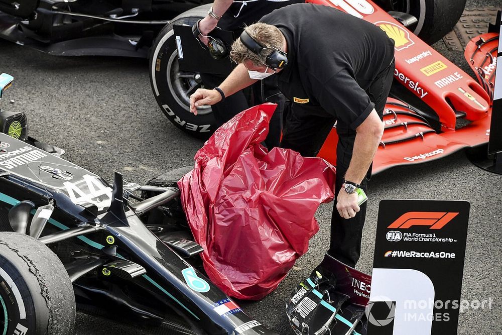 Un tecnico della Pirelli, copre la gomma forata di Lewis Hamilton, Mercedes F1 W11, nel Parc Ferme