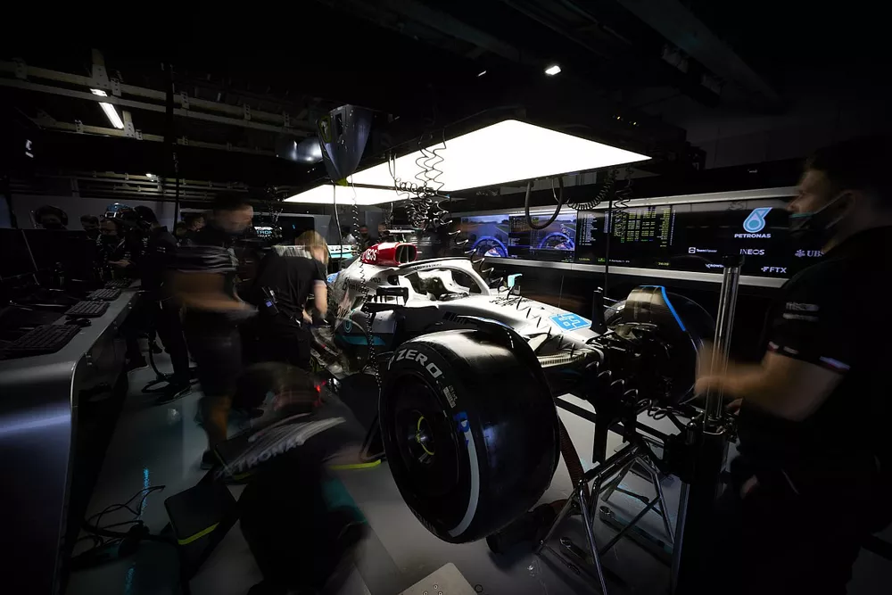 Les mécaniciens travaillent sur la monoplace de George Russell Mercedes W13 dans son garage