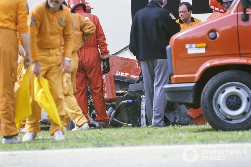 Marshals attend Gerhard Berger's Ferrari 640 after an accident