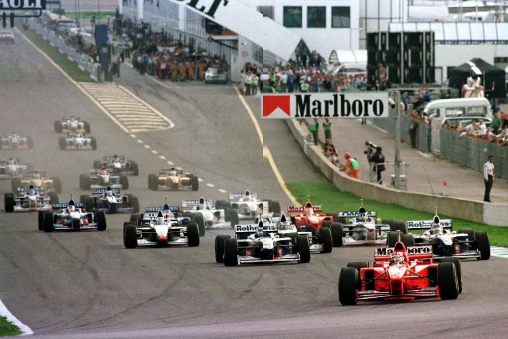 Michael Schumacher (Ferrari F310B) leads Championship-rival Jacques Villeneuve (Williams FW19-Renault) at the start.