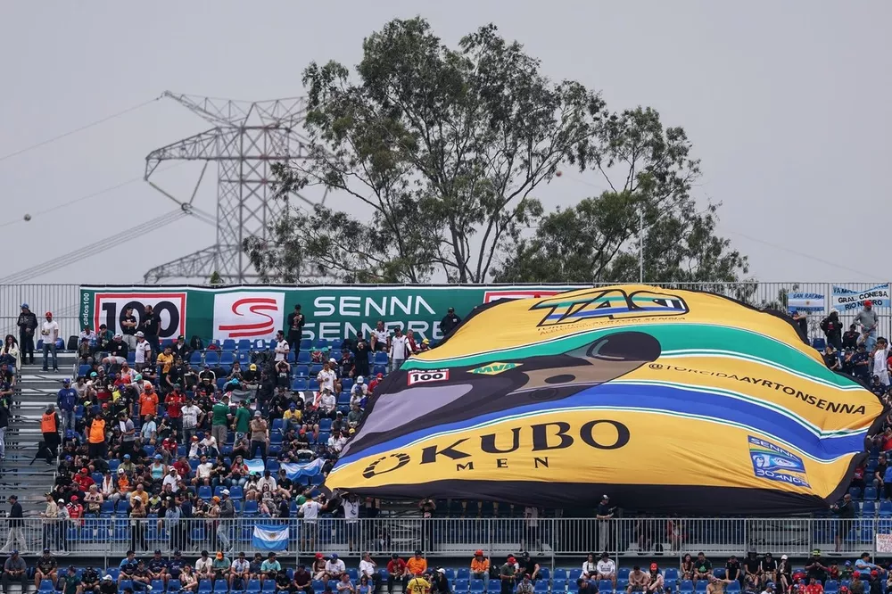 Fans unfurl a big Ayrton Senna helmet in a grandstand