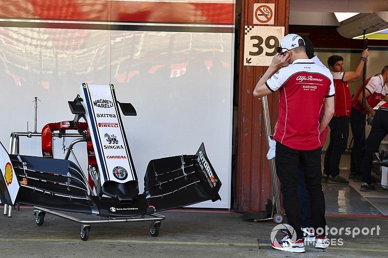 Kimi Raikkonen, Alfa Romeo Racing, examina un alerón delantero