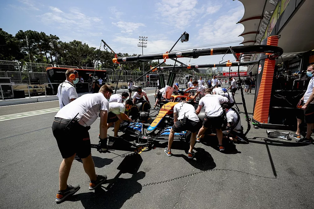 L'&eacute;quipe d'arr&ecirc;t au stand de McLaren s'entra&icirc;ne avec une McLaren MCL35M 