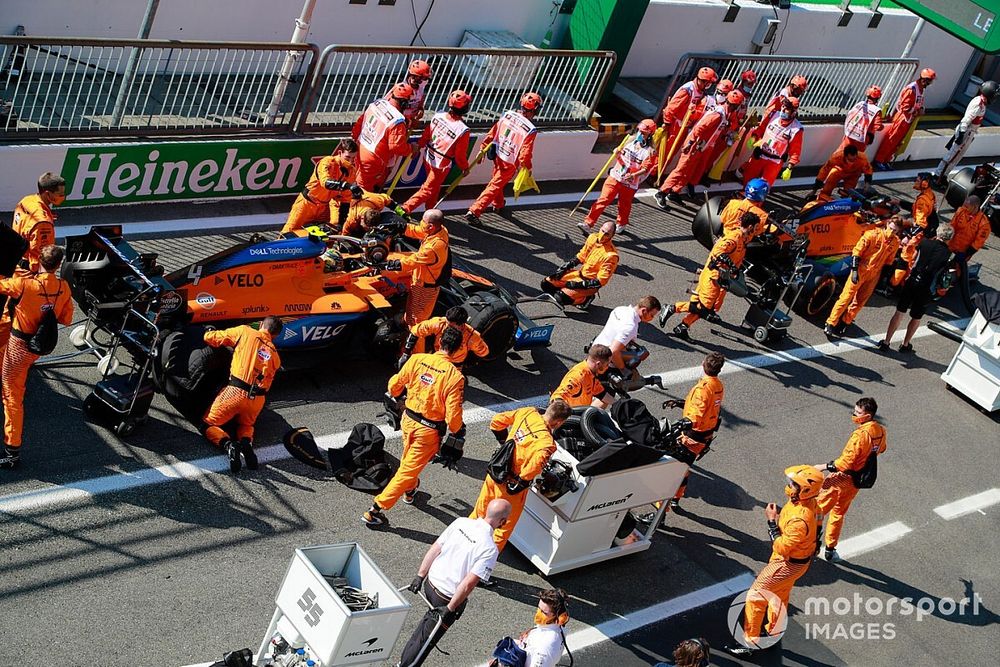 Lando Norris, McLaren MCL35, in de pits met monteurs tijdens de rode vlag