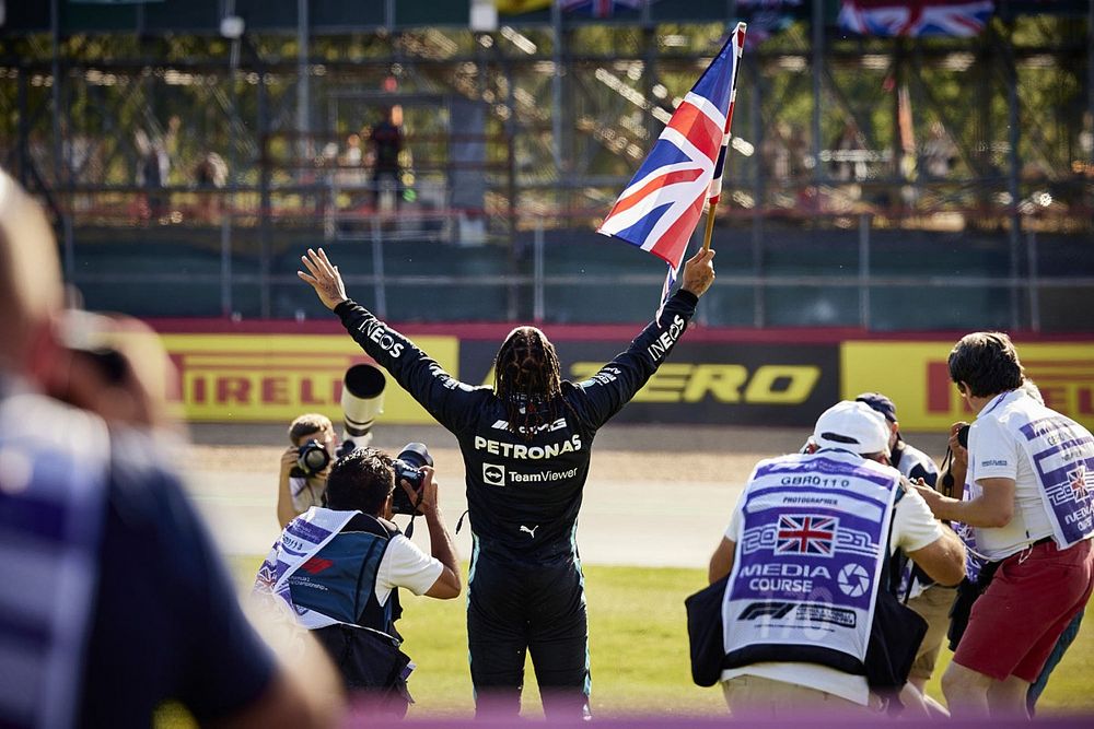 Lewis Hamilton, Mercedes , 1st position, celebrates with a Union flag after the race