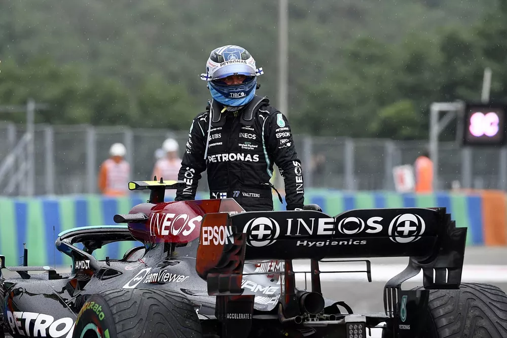 Valtteri Bottas, Mercedes, walks away from his damaged car after crashing out at the start