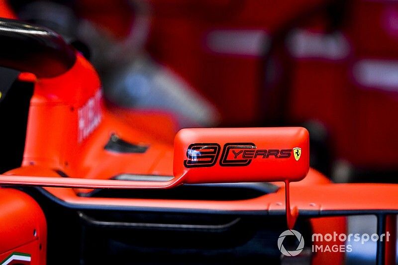 Logo de 90 años en el espejo de un Ferrari SF90.