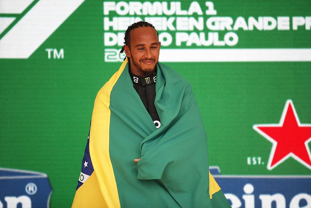 Lewis Hamilton, Mercedes, 1st position, celebrates on the podium with a Brazilian flag