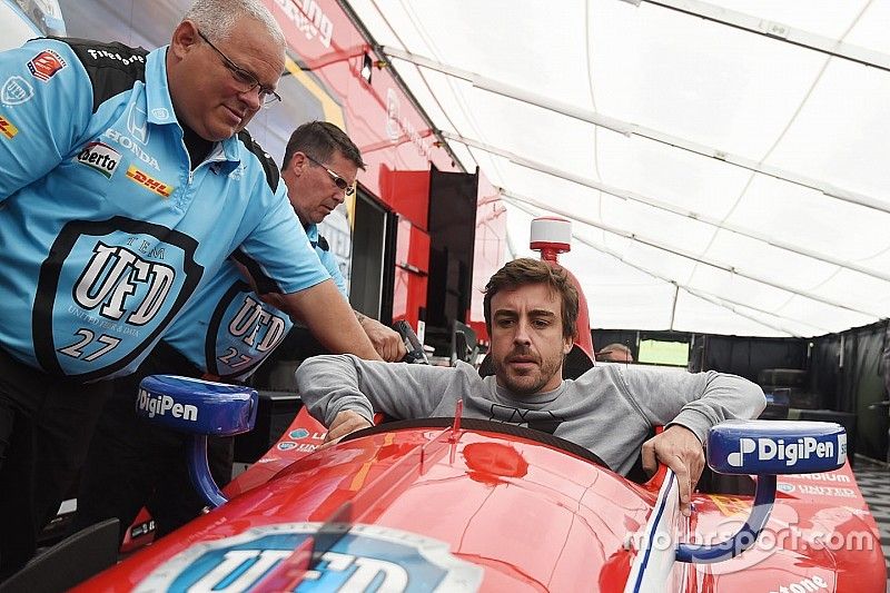 Fernando Alonso sits in the car of Marco Andretti