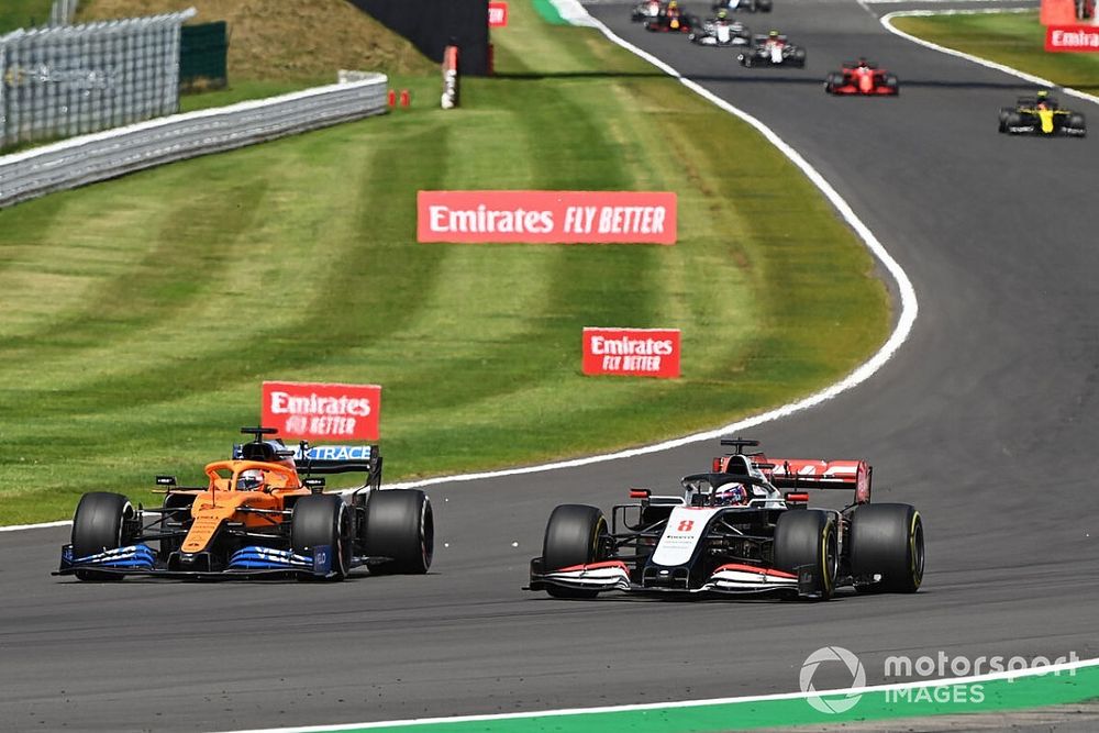 Carlos Sainz Jr., McLaren MCL35, battles with Romain Grosjean, Haas VF-20