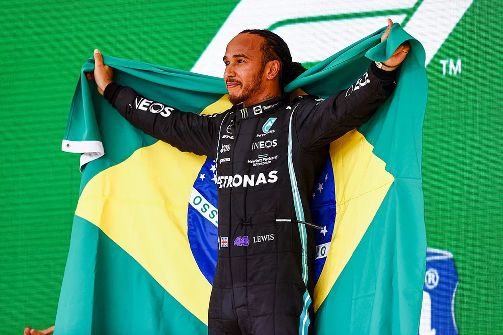 Lewis Hamilton, Mercedes, 1st position, celebrates on the podium with a Brazilian flag