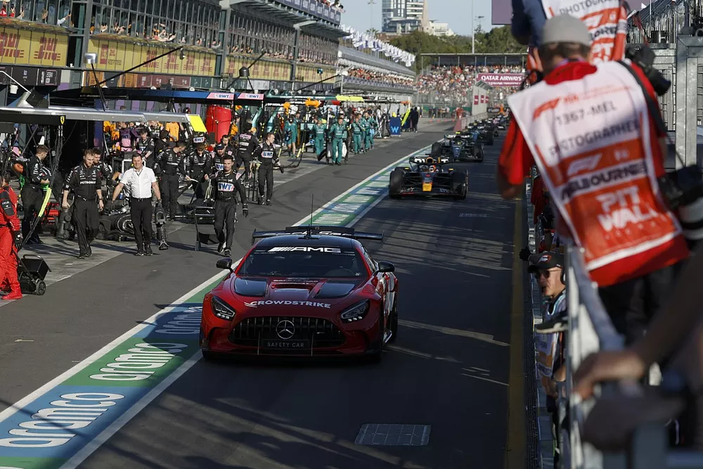 De Safety Car Max Verstappen, Red Bull Racing RB19, Lewis Hamilton, Mercedes F1 W14, de rest van het veld uit de pits voor een herstart.