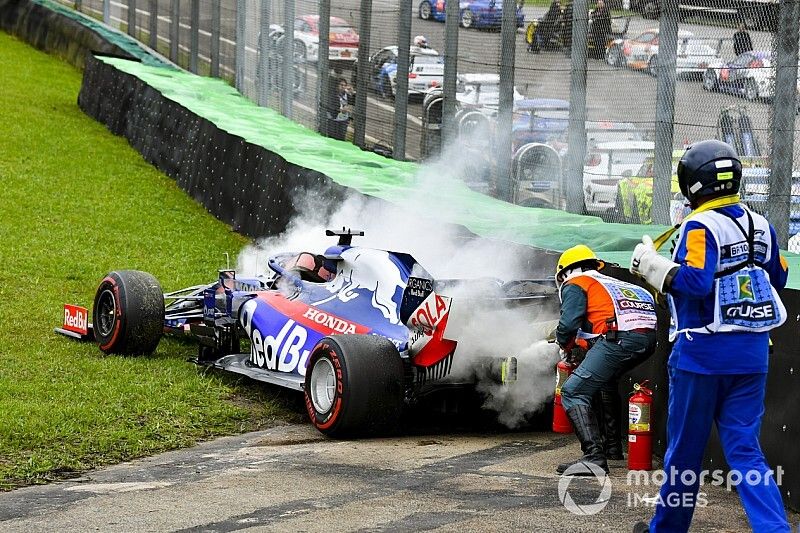 Oficiales utilizando el extintor de incendios en el coche de Daniil Kvyat, Toro Rosso STR14 después de un accidente.