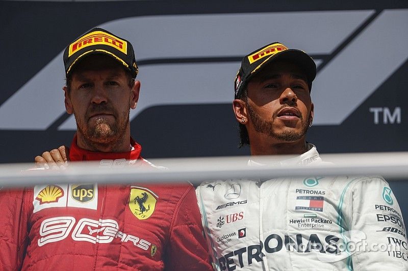 Lewis Hamilton, Mercedes AMG F1 puts his arm around Sebastian Vettel, Ferrari on the podium