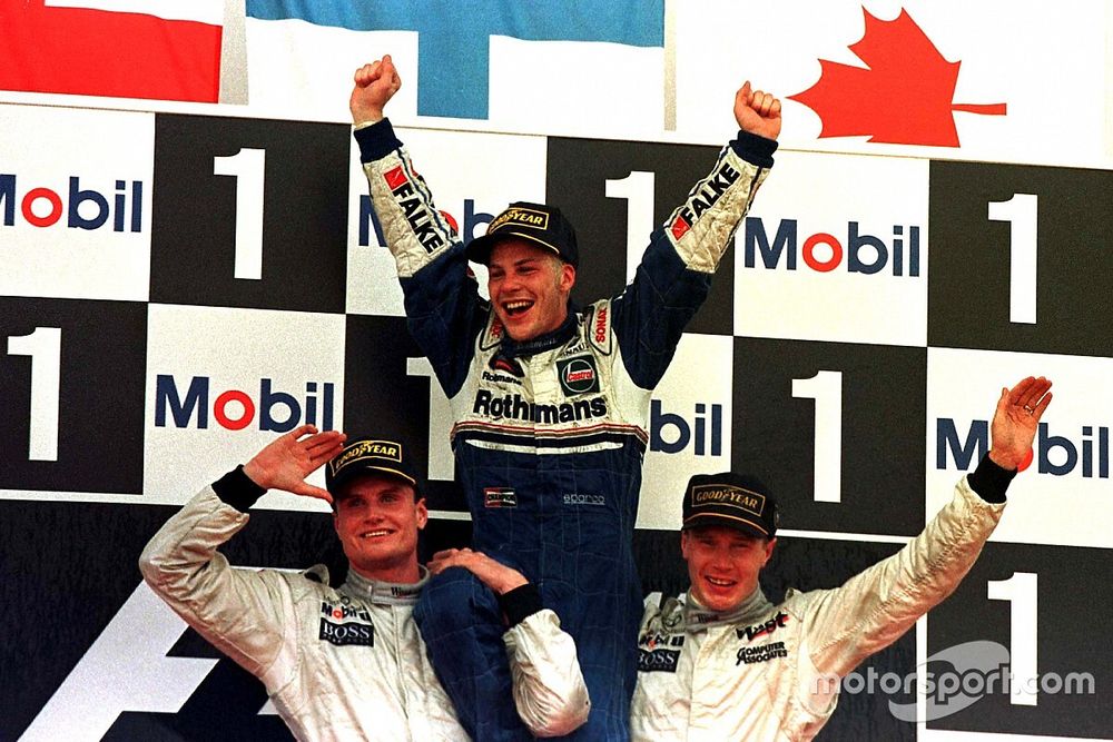 Jacques Villeneuve, Williams is lifted shoulder high by Mika Hakkinnen, McLaren and David Coulthard,