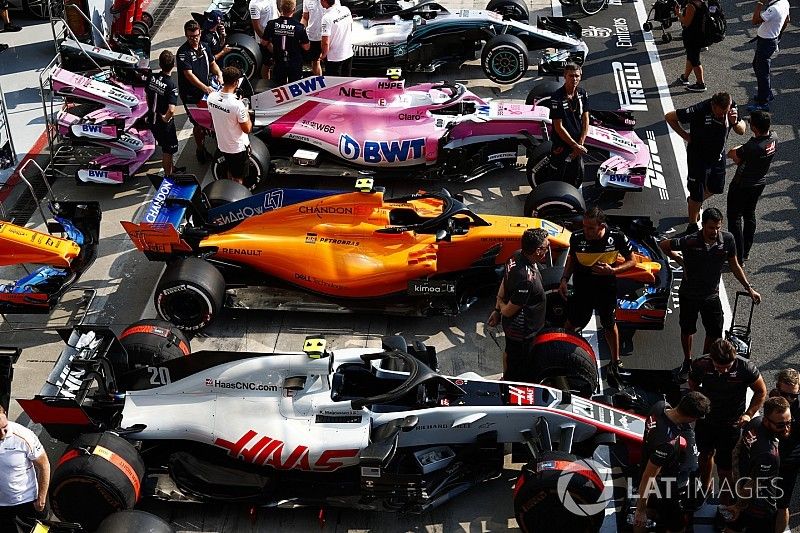 Cars of Kevin Magnussen, Haas F1 Team VF-18, Lando Norris, McLaren MCL33, Esteban Ocon, Racing Point Force India VJM11, and Lewis Hamilton, Mercedes AMG F1 W09, line up in the pit lane