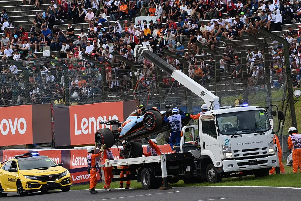 Marshals remove the damaged car of Logan Sargeant, Williams FW45, from the circuit after a crash in Q1