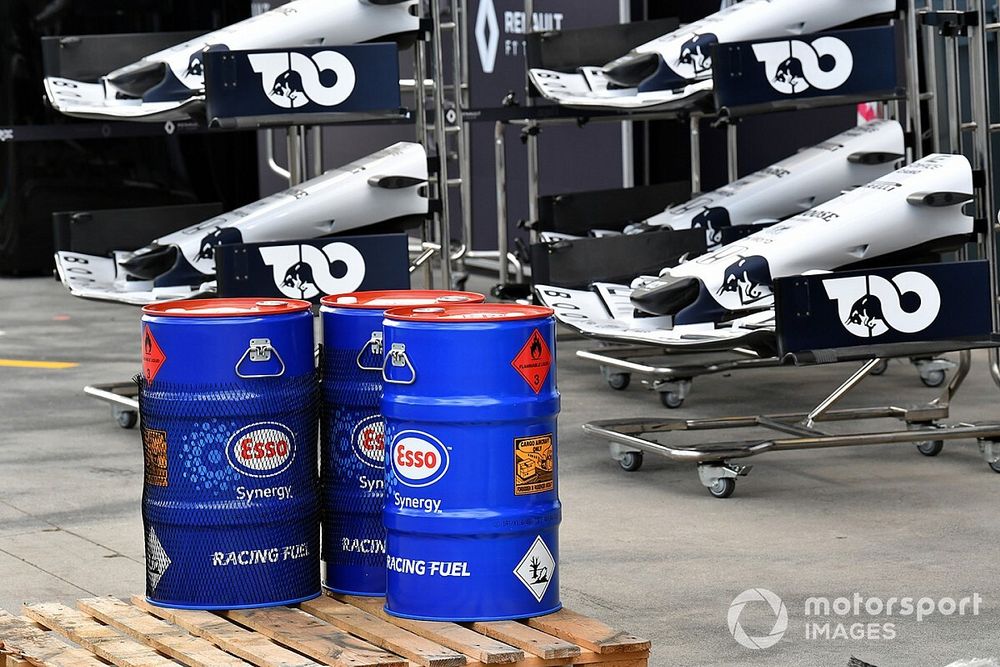 Esso oil drums in front of spare AlphaTauri noses and front wings