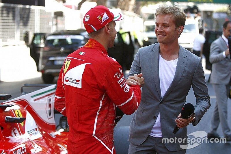 Racewinnaar Sebastian Vettel, Ferrari, wordt geïnterviewd door regerend wereldkampioen Nico Rosberg