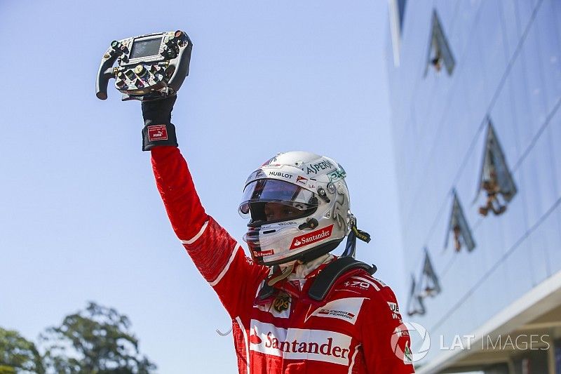 El ganador de la carrera de Brasil, Sebastian Vettel, Ferrari, sujeta el volante de su coche