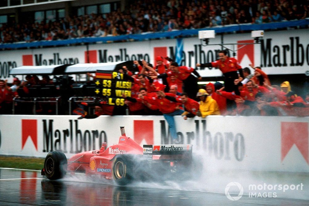 Winnaar Michael Schumacher, Ferrari F310 passeert de finishvlag