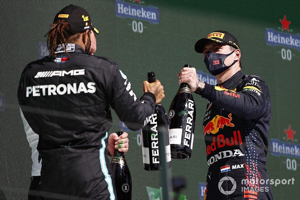 Lewis Hamilton, Mercedes, 1st position, the Mercedes trophy delegate and Max Verstappen, Red Bull Racing, 2nd position, celebrate with Champagne on the podium