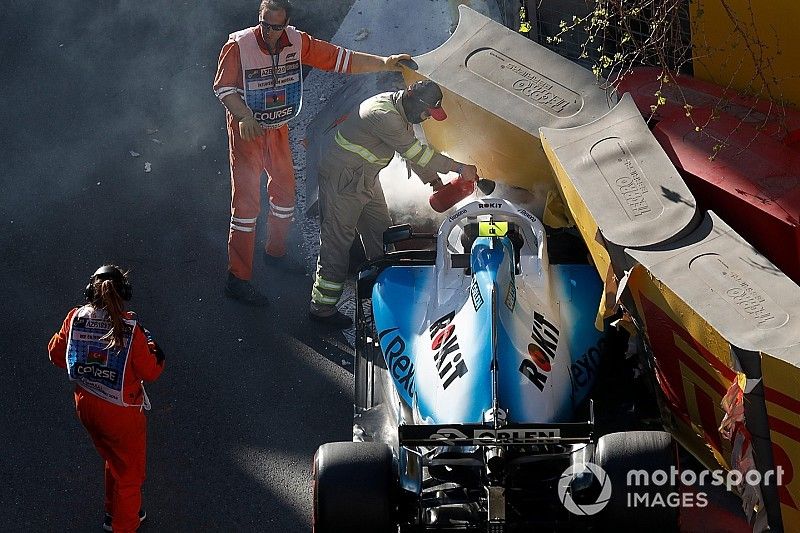 Crews remove the crashed car of Robert Kubica, Williams