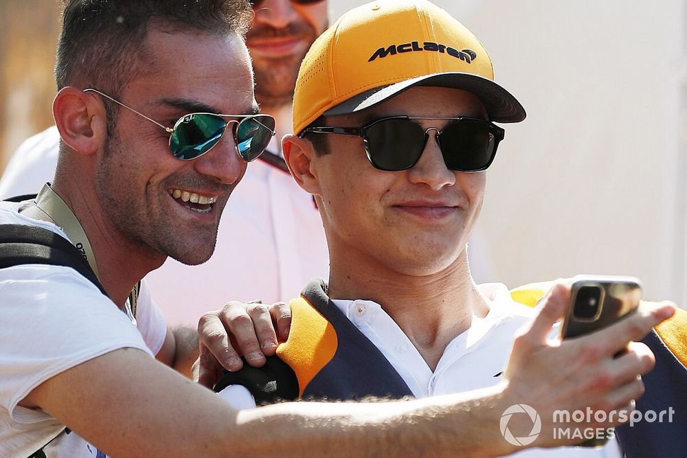 Lando Norris, McLaren, poses for a selfie with a fan