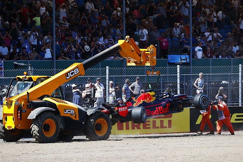 Marshals halen de wagen van de gecrashte Max Verstappen Red Bull Racing RB14 weg