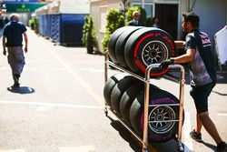 Un miembro del equipo Red Bull Racing transporta neumáticos en el paddock