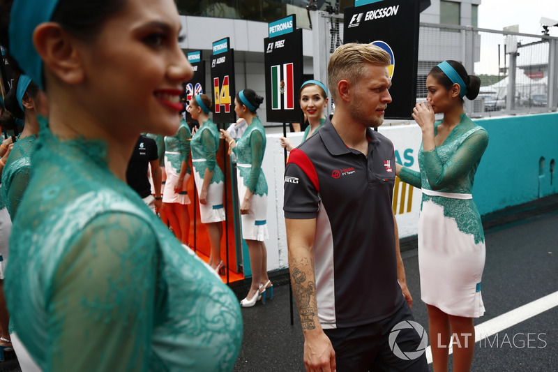 Kevin Magnussen, Haas F1 Team, walks through a corridor of grid girls