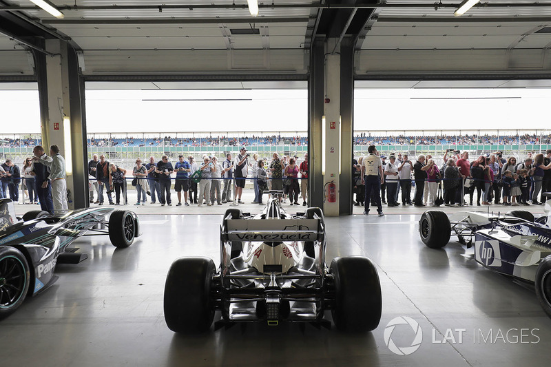 Fans view a garage filled with classic Williams F1 machinery