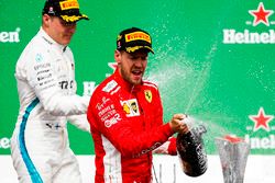 Valtteri Bottas, Mercedes AMG F1, 2nd position, and Sebastian Vettel, Ferrari, 1st position, spray Champagne on the podium