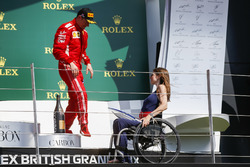 Third place Kimi Raikkonen, Ferrari, receives his trophy from Nathalie McGoin on the podium