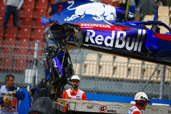 Marshals remove the damaged car of Brendon Hartley, Toro Rosso STR13, from the circuit as the gearbox hangs off the back