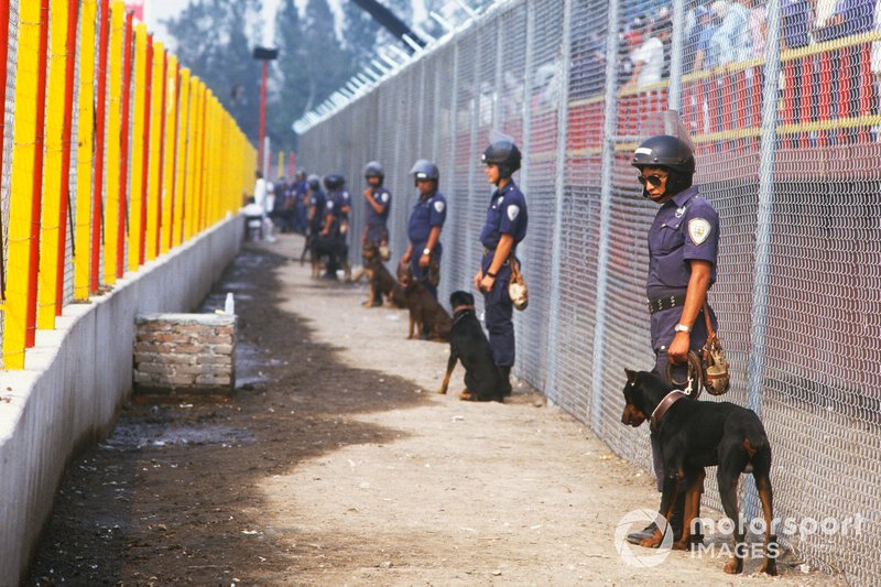 Policias con perros de vigilancia entre la pista y las gradas