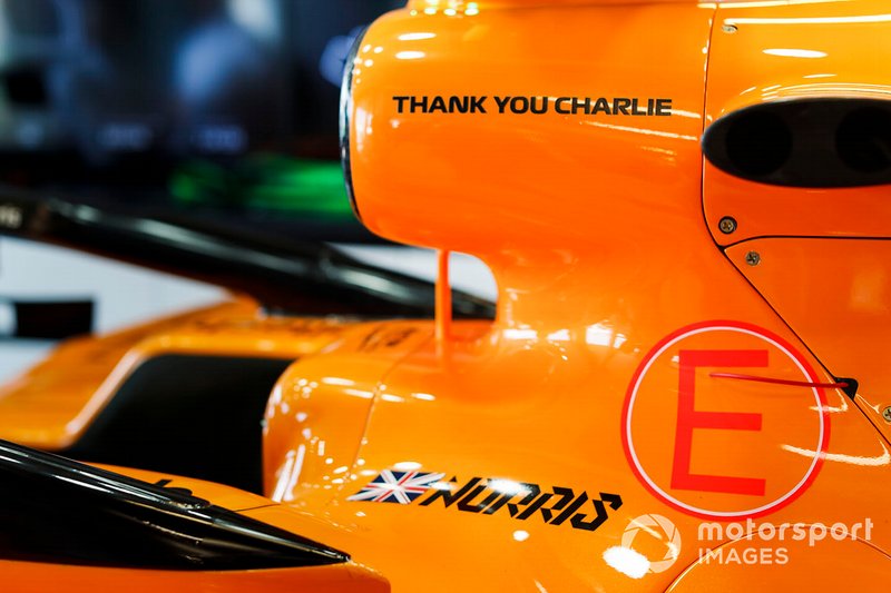 Coche de Lando Norris, McLaren MCL34 en el garaje con un gráfico de agradecimiento en memoria de Charlie Whiting