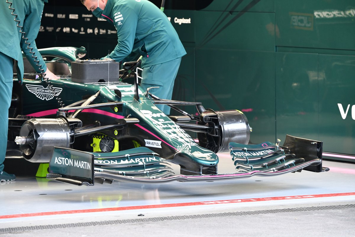 Esta foto do Aston Martin nos permite ver a entrada do duto de freio em forma de L, com suas inumerosas aberturas e a saída que alimenta parte do fluxo de ar jogado para fora da roda para alterar a turbulência.