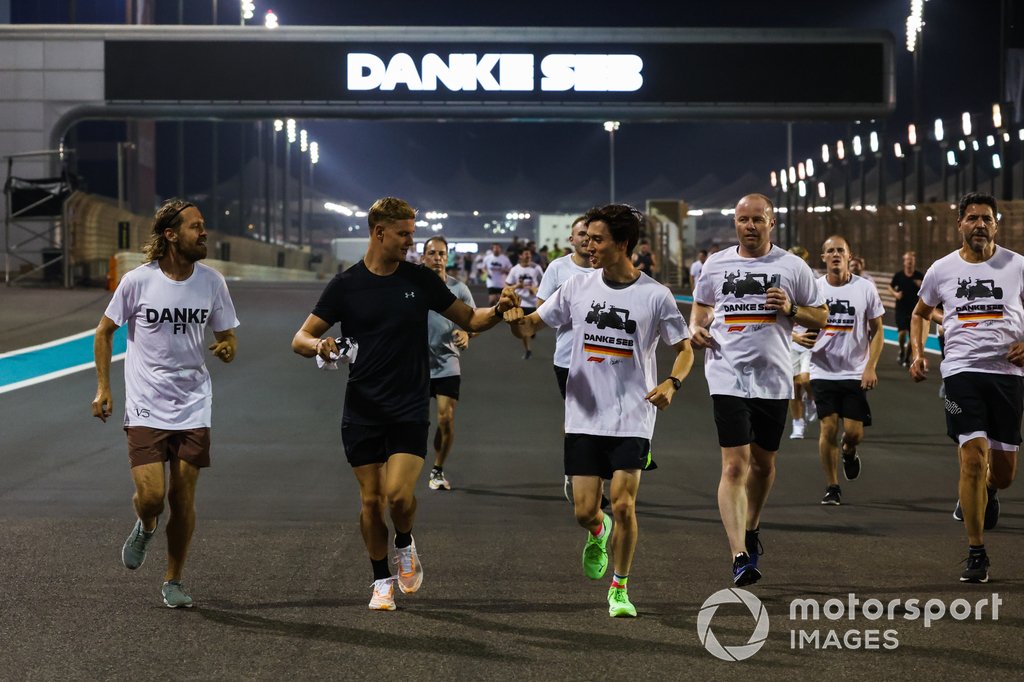 Sebastian Vettel, Aston Martin, es acompañado en una carrera alrededor del circuito por Mick Schumacher, Haas F1 Team, Jack Aitken, miembros de su equipo y simpatizantes como parte de su despedida en su último Gran Premio