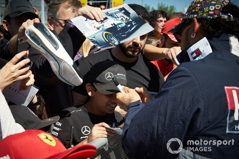 Lewis Hamilton, Mercedes AMG F1 signs a hat for a young fan