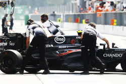 Jenson Button, McLaren is wheeled back into the garage in the pit lane