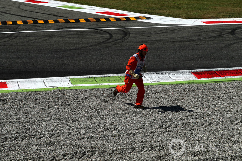 Marshal runs across the track