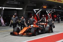 The McLaren team return Fernando Alonso, McLaren MCL32, to the garage